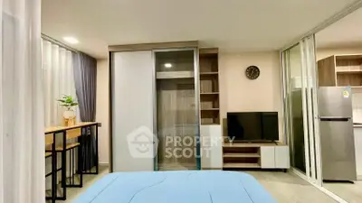 Modern studio apartment with sleek design, featuring a cozy bed, stylish furniture, and a compact kitchen area.
