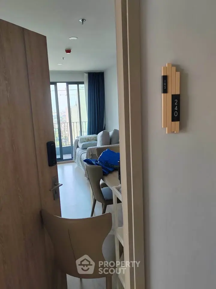 Modern apartment entrance leading to a cozy living room with balcony view.
