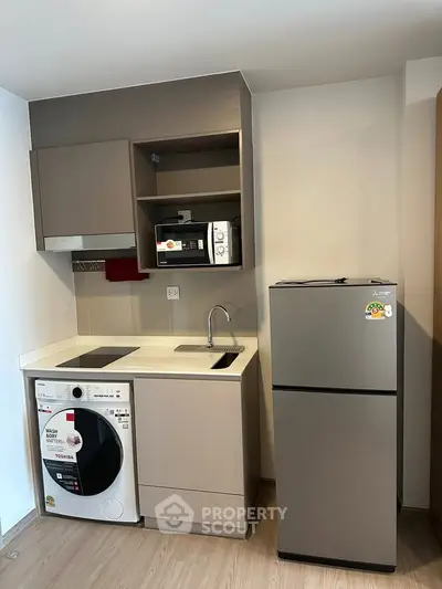 Modern compact kitchen with appliances including fridge, washing machine, and microwave.