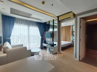 Modern living room with large windows and adjacent bedroom in a stylish apartment.