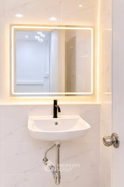 Modern bathroom with illuminated mirror and sleek sink design