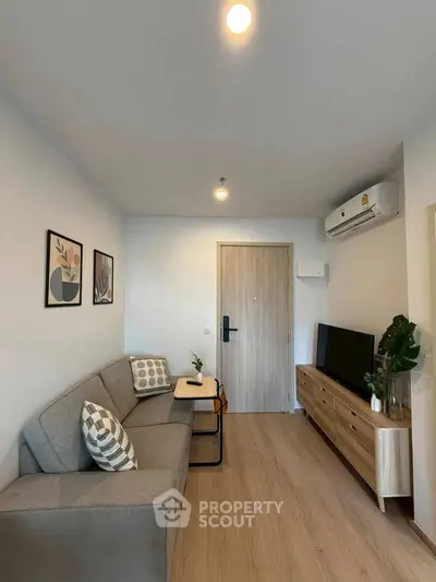 Modern living room with cozy sofa and stylish decor in a compact apartment.
