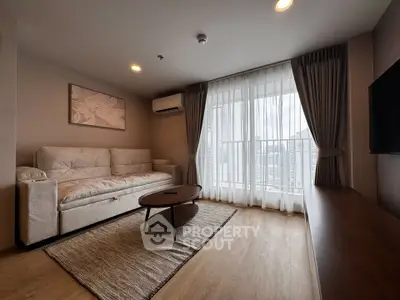 Modern living room with large window and city view, featuring cozy sofa and stylish decor.
