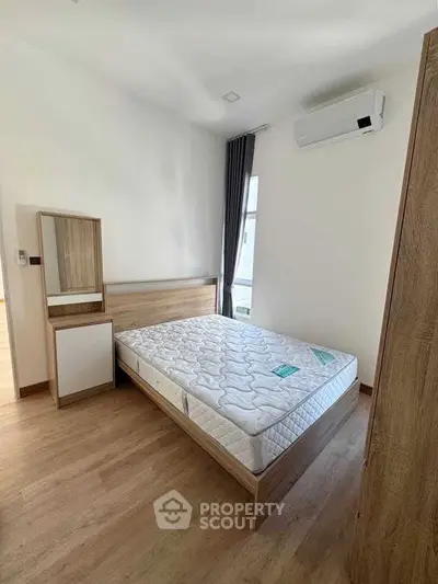 Modern bedroom with wooden furniture and air conditioning in a bright apartment.