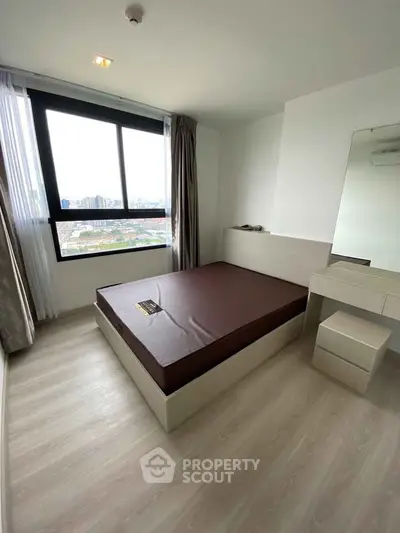 Modern bedroom with large window and minimalist furniture in high-rise apartment.