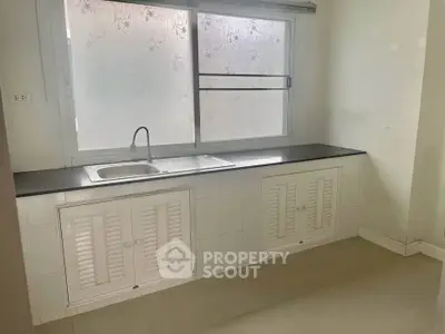 Minimalist kitchen with large window and sleek countertop