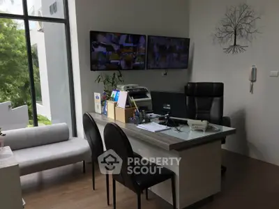 Modern office space with sleek furniture and large windows offering natural light.