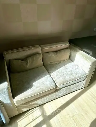 Cozy two-seater sofa in a sunlit living room with elegant decor.