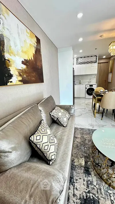 Luxurious living room with elegant decor and modern kitchen in open layout apartment.