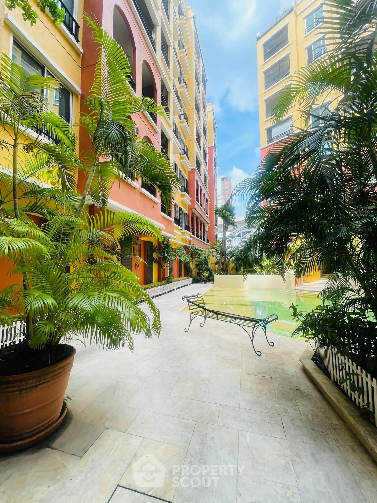 Vibrant courtyard with lush greenery and colorful building facade