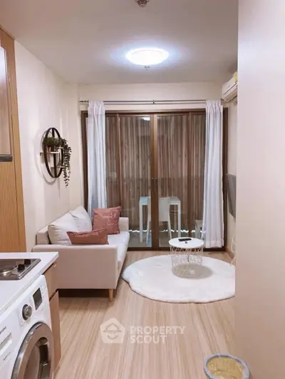 Cozy living room with washing machine and balcony access in modern apartment