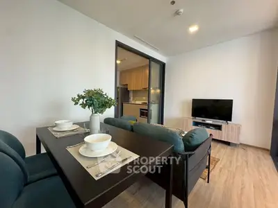 Modern living room with dining area and open kitchen in stylish apartment.