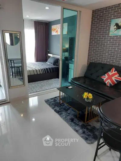 Modern living room with stylish decor and view into cozy bedroom