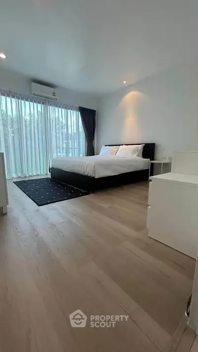 Spacious modern bedroom with large windows and elegant decor