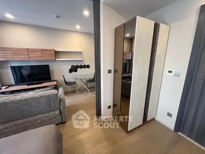 Modern living room with stylish furniture and open layout, featuring a cozy sofa and sleek TV setup.