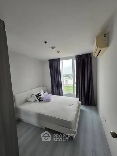 Modern bedroom with large window and air conditioning in a stylish apartment.