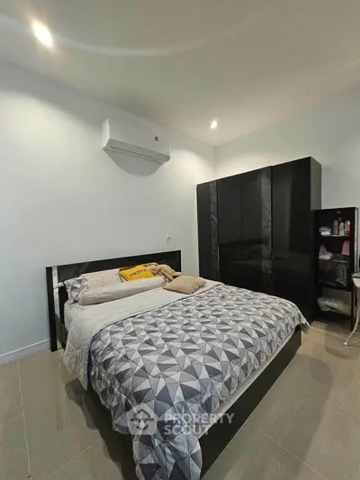 Modern bedroom with stylish decor and ample storage space, featuring a comfortable bed and sleek wardrobe.