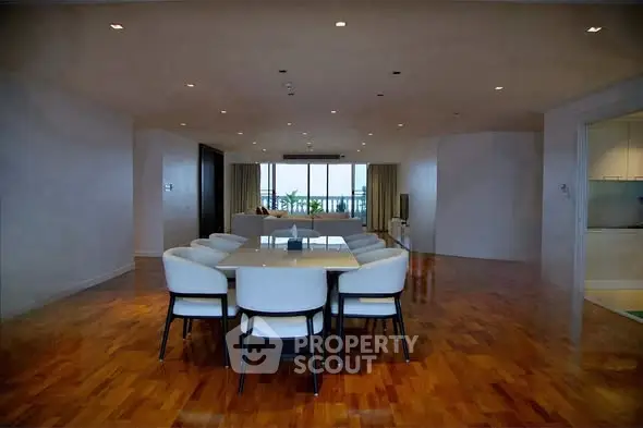 Spacious open-plan living and dining area with elegant hardwood floors and modern furnishings.