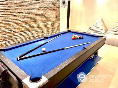 Stylish game room with modern pool table and cozy seating area