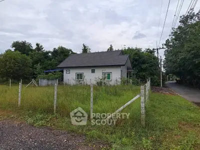 Charming countryside house with lush greenery and fenced yard, perfect for serene living.
