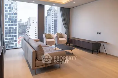 Modern living room with city view, featuring sleek furniture and large windows in a high-rise apartment.