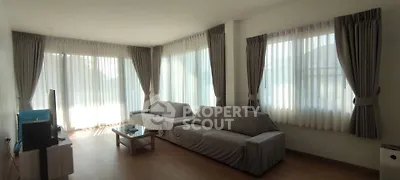Spacious living room with large windows and modern furniture, perfect for relaxation.