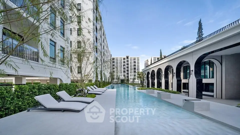 Luxurious modern apartment complex with stunning pool and elegant architecture.