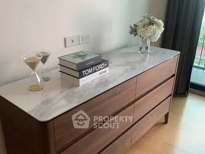 Stylish bedroom dresser with marble top and decor in modern apartment.