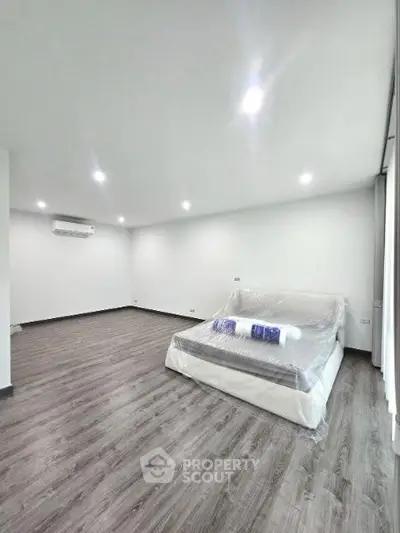 Spacious bedroom with modern flooring and natural light