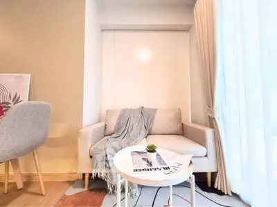 Cozy living room with modern decor and natural light, featuring a stylish sofa and elegant curtains.