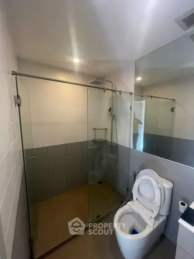 Modern bathroom with glass shower enclosure and large mirror