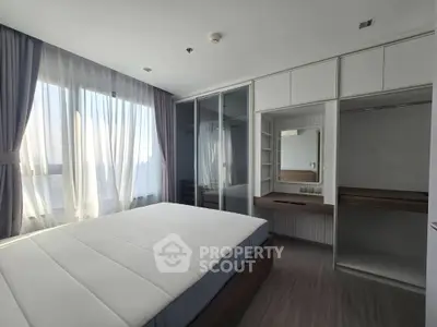 Modern bedroom with large window and built-in closet in a stylish apartment.