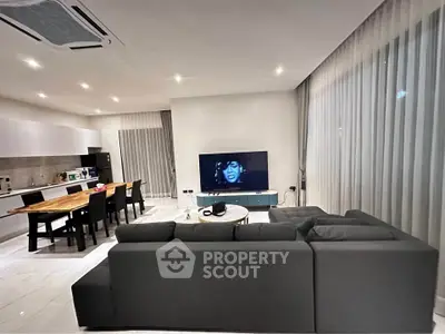 Modern living room with sleek furniture and open kitchen layout, perfect for contemporary living.