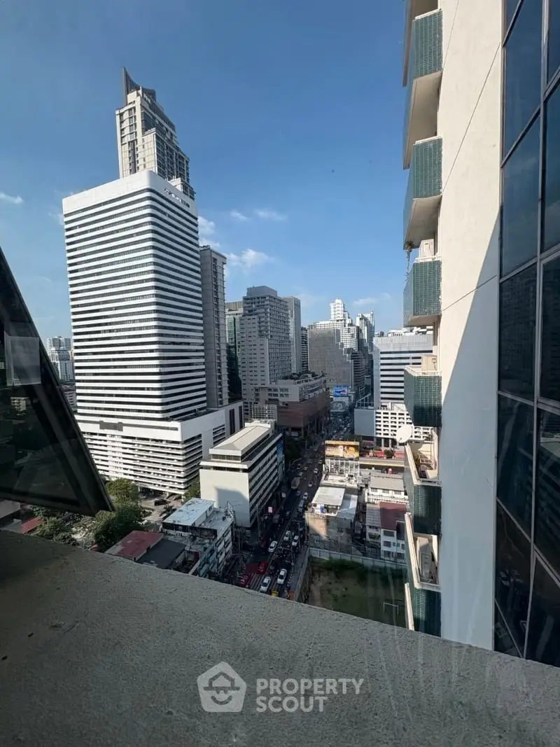 Stunning cityscape view from a high-rise building balcony in vibrant urban area.
