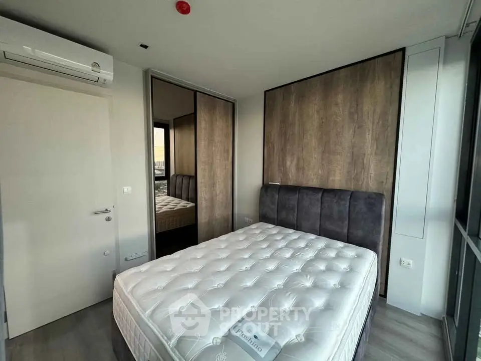 Modern bedroom with large mirrored closet and plush bed in stylish apartment.