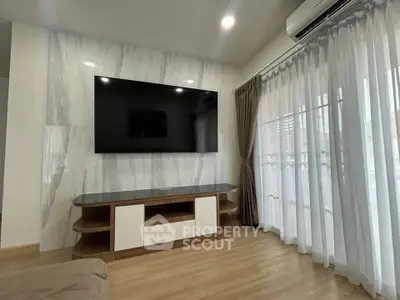 Modern living room with large TV and elegant curtains