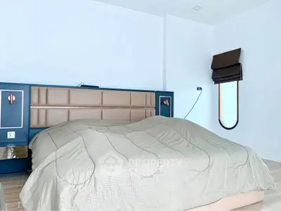 Spacious modern bedroom with stylish headboard and cozy bedding