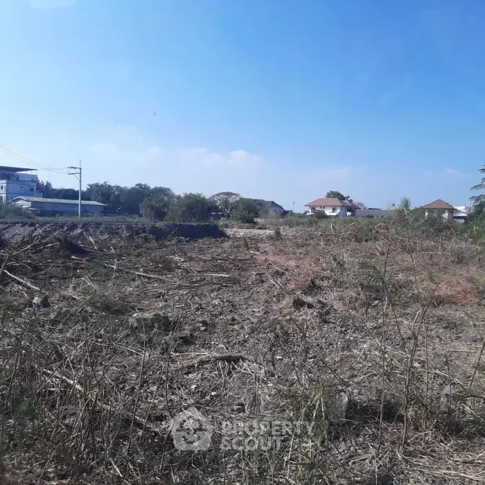 Vacant land plot with clear sky, ideal for development opportunities.