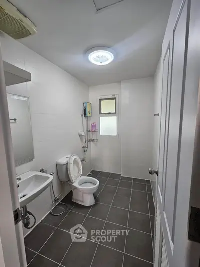 Modern bathroom with sleek fixtures and tiled flooring in a contemporary home.