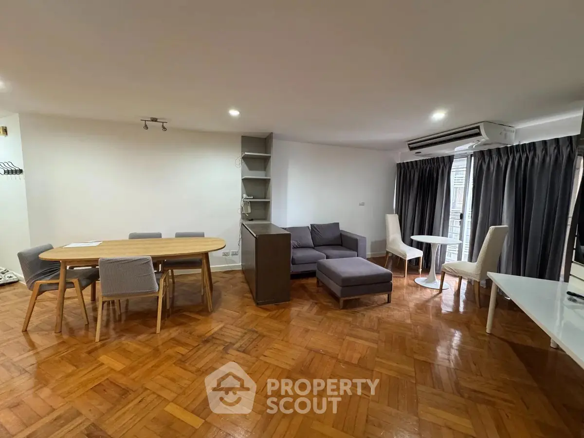 Spacious living room with parquet flooring and modern furniture in a stylish apartment.