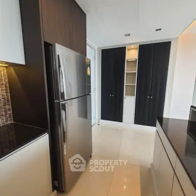 Modern kitchen with sleek cabinetry and stainless steel refrigerator