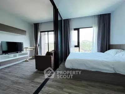 Modern bedroom with large windows and scenic view, featuring a cozy bed and sleek furnishings.