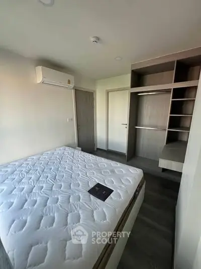 Modern bedroom with built-in wardrobe and air conditioning in a stylish apartment.
