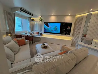 Luxurious modern living room with stylish decor and large TV, perfect for relaxation and entertainment.