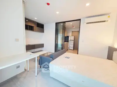 Modern studio apartment with sleek design and ample natural light, featuring a cozy living area and efficient layout.