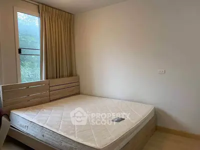 Cozy bedroom with natural light and minimalist decor, featuring a comfortable mattress and wooden bed frame.