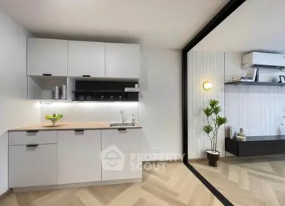 Modern kitchen with sleek cabinetry and open layout adjacent to stylish living area.