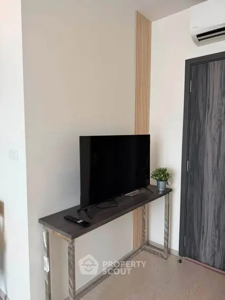 Modern living room corner with sleek TV stand and air conditioning unit.