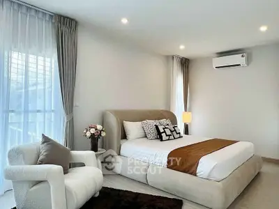 Modern bedroom with elegant decor, featuring a cozy bed, stylish armchair, and soft lighting.