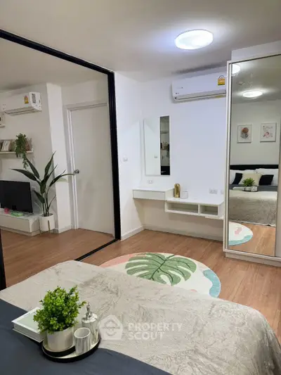 Modern bedroom with stylish decor, mirrored wardrobe, and cozy ambiance in a contemporary apartment.
